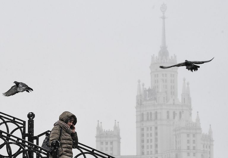 Женщина идет по Таможенному пешеходному мосту через реку Яузу, соединяющему Золоторожскую и Сыромятническую набережные в Москве