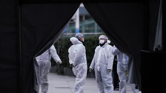Медики в защитных костюмах на железнодорожной станции Шанхая Медики в защитных костюмах на железнодорожной станции Шанхая