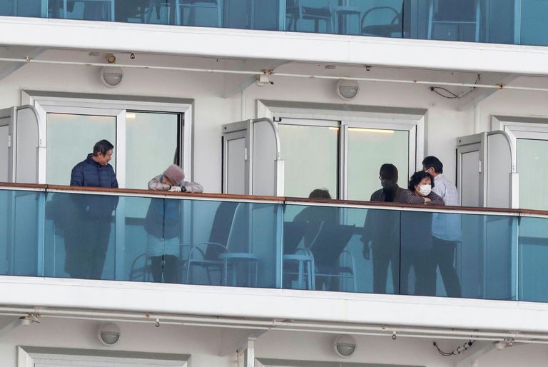 Пассажиры на палубе круизного судна Diamond Princess в порту Йокогамы Пассажиры на палубе круизного судна Diamond Princess в порту Йокогамы