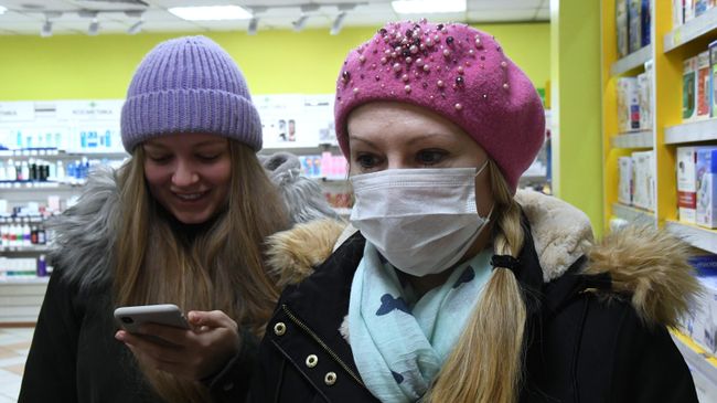 Покупательница в защитной маске в аптеке Владивостока Покупательница в защитной маске в аптеке Владивостока