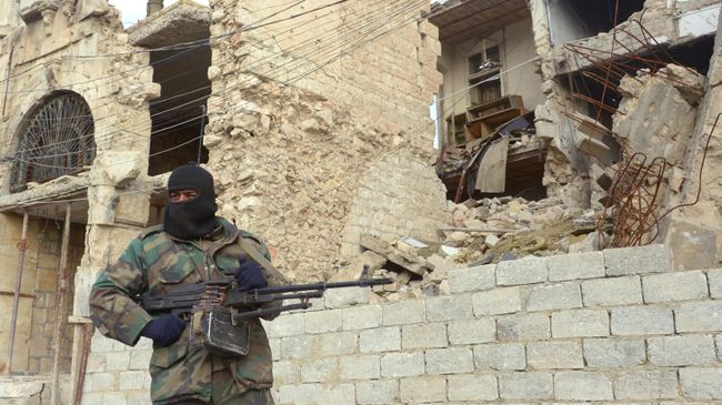 Сирийский военный рядом с разрушенным зданием в Алеппо Сирийский военный рядом с разрушенным зданием в Алеппо