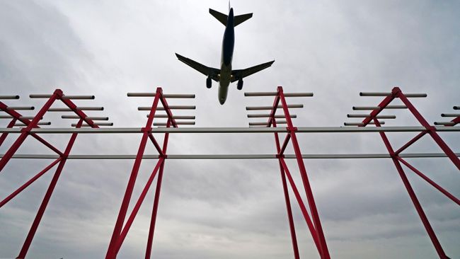 Самолет пролетает над курсовым радиомаяком системы посадки в аэропорту Самолет пролетает над курсовым радиомаяком системы посадки в аэропорту