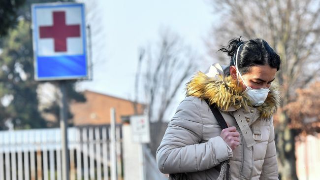 Женщина в защитной маске покидает больницу Кодоньо в северной Италии Женщина в защитной маске покидает больницу Кодоньо в северной Италии