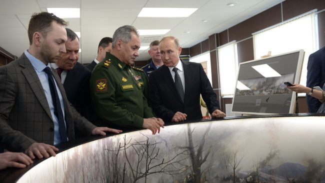 Верховный главнокомандующий, президент РФ Владимир Путин и министр обороны РФ Сергей Шойгу осматривают макет - реконструкцию высоты, на которой произошло противостояние бойцов 6-й роты и боевиков