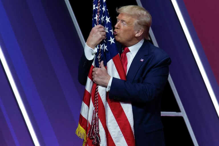 Президент США Дональд Трамп целует американский флаг после выступления на Конференции консервативных политических действий Президент США Дональд Трамп целует американский флаг после выступления на Конференции консервативных политических действий