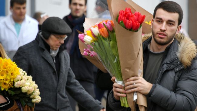 Покупатель с цветами на Рижском рынке в Москве