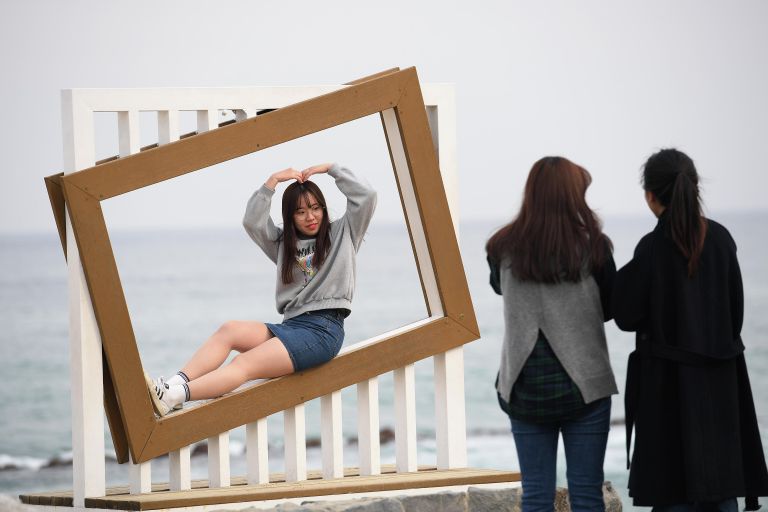 Девушки фотографируются на пляже Gyeongpo Beach в городе Каннын, Республика Корея Девушки фотографируются на пляже Gyeongpo Beach в городе Каннын, Республика Корея