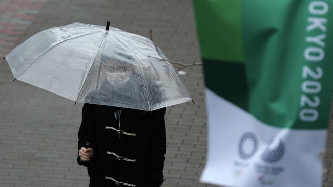 A man, wearing a protective face mask, following an outbreak of the coronavirus disease (COVID-19), walks next to a banner for Tokyo 2020 Olympic games in Tokyo, Japan March 8, 2020. REUTERS/Stoyan Nenov A man, wearing a protective face mask, following an outbreak of the coronavirus disease (COVID-19), walks next to a banner for Tokyo 2020 Olympic games in Tokyo, Japan March 8, 2020. REUTERS/Stoyan Nenov