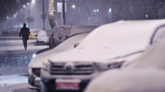 Мужчина идет по улице во время снегопада в Москве Мужчина идет по улице во время снегопада в Москве