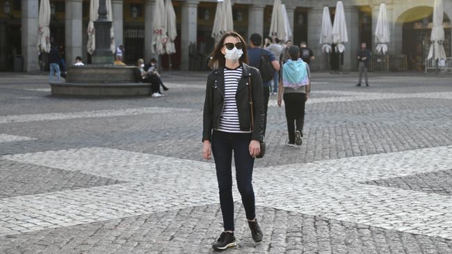 Девушка в защитной маске на площади Пласа-Майор в центре Мадрида