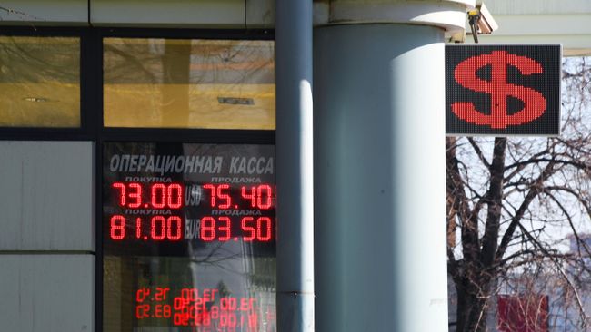 Табло курса обмена доллара и евро к рублю на одной из улиц в Москве