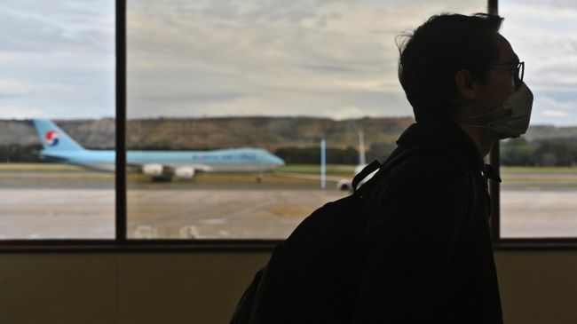 Мужчина в защитной маске в аэропорту