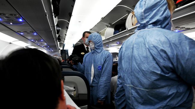 Сотрудники Роспотребнадзора измеряют температуру пассажиров на борту самолета в аэропорту Шереметьево Сотрудники Роспотребнадзора измеряют температуру пассажиров на борту самолета в аэропорту Шереметьево