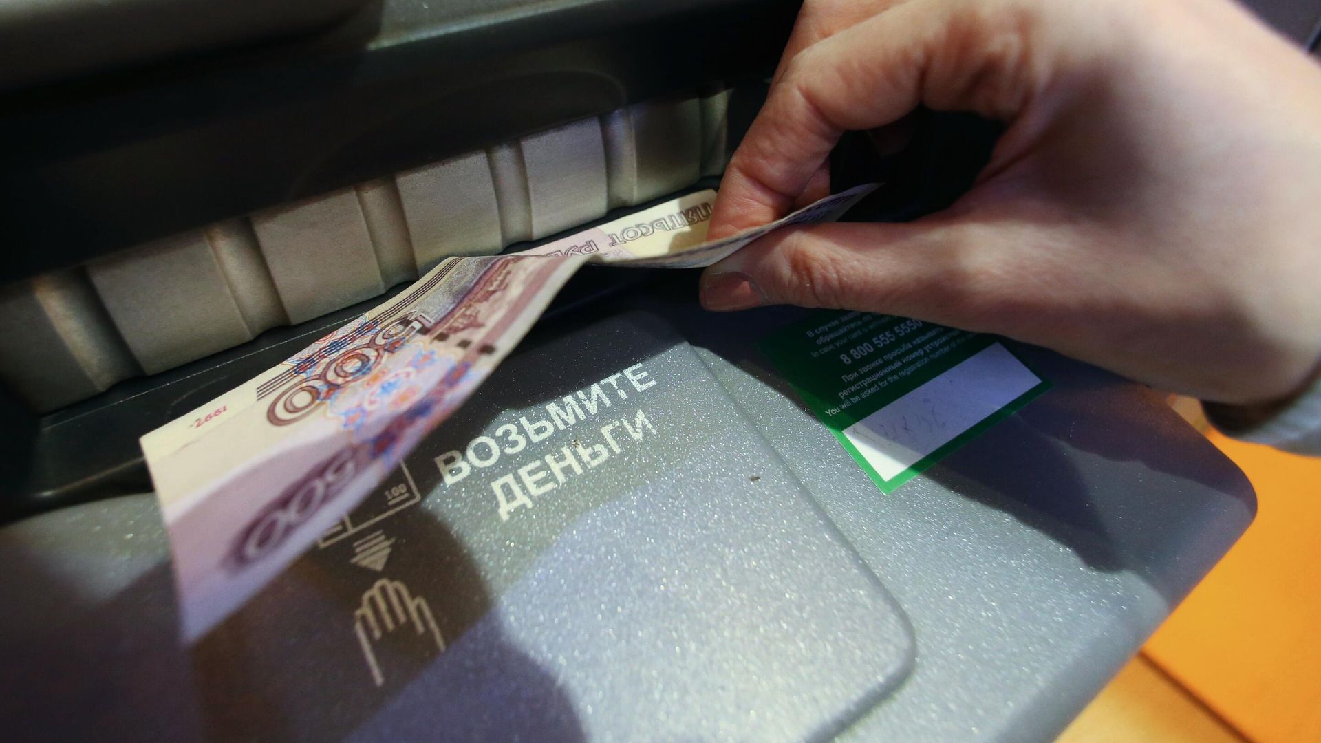 Женщина получает наличные деньги в банкомате Женщина получает наличные деньги в банкомате - РИА Новости, 1920, 29.10.2020