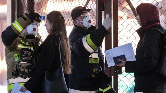 Польские сотрудники измеряют температуру тела пассажиров прибывших поездом из Украины на железнодорожном вокзале в Перемышле Польские сотрудники измеряют температуру тела пассажиров прибывших поездом из Украины на железнодорожном вокзале в Перемышле