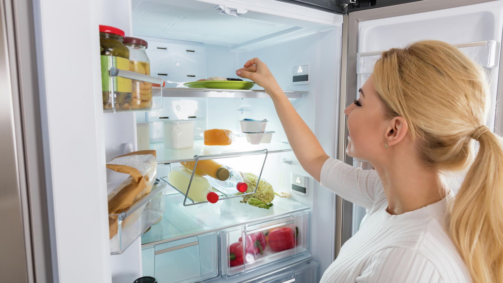 Девушка достает продукты из холодильника Девушка достает продукты из холодильника - РИА Новости, 1920, 06.04.2021
