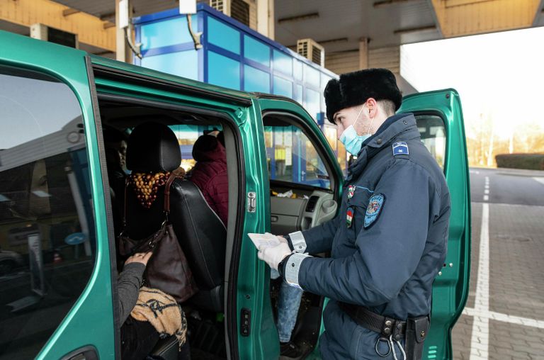 Сотрудник венгерской полиции проверяет документы украинских рабочих, покидающих Венгрию на пограничном пункте в городе Захонь, северо-восточная Венгрия Сотрудник венгерской полиции проверяет документы украинских рабочих, покидающих Венгрию на пограничном пункте в городе Захонь, северо-восточная Венгрия