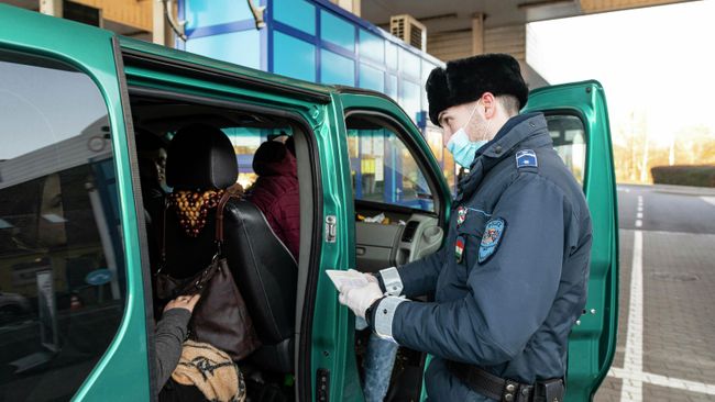 Сотрудник венгерской полиции проверяет документы украинских рабочих, покидающих Венгрию на пограничном пункте в городе Захонь, северо-восточная Венгрия Сотрудник венгерской полиции проверяет документы украинских рабочих, покидающих Венгрию на пограничном пункте в городе Захонь, северо-восточная Венгрия
