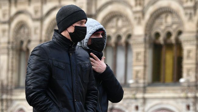 Прохожие в защитных масках на Красной площади в Москве Прохожие в защитных масках на Красной площади в Москве