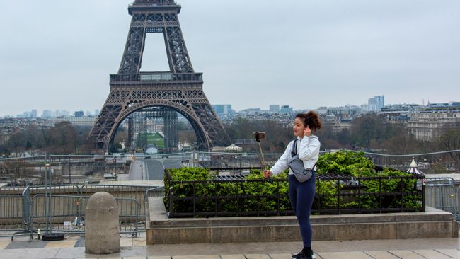 Туристка фотографируется на безлюдной площади Трокадеро у Эйфелевой башни в Париже Туристка фотографируется на безлюдной площади Трокадеро у Эйфелевой башни в Париже