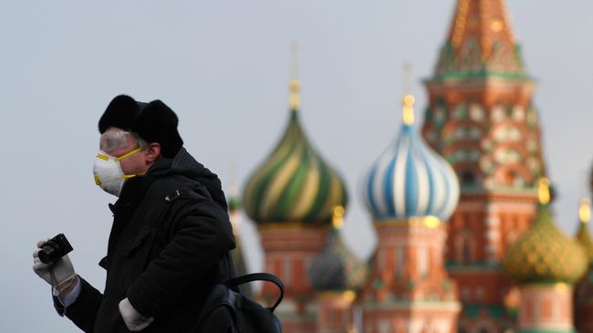 Прохожий в медицинской маске на Красной Площади в Москве Прохожий в медицинской маске на Красной Площади в Москве