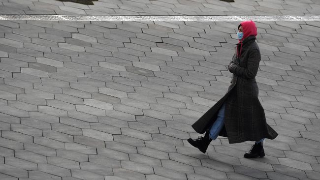 Женщина в медицинской маске на одной из улиц Москвы