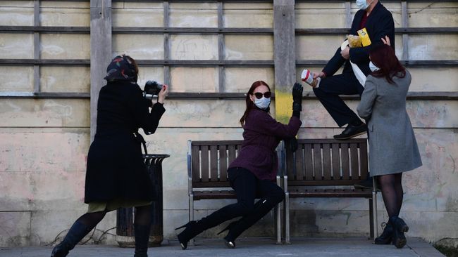 Молодые люди фотографируются на одной из улиц в Москве Молодые люди фотографируются на одной из улиц в Москве