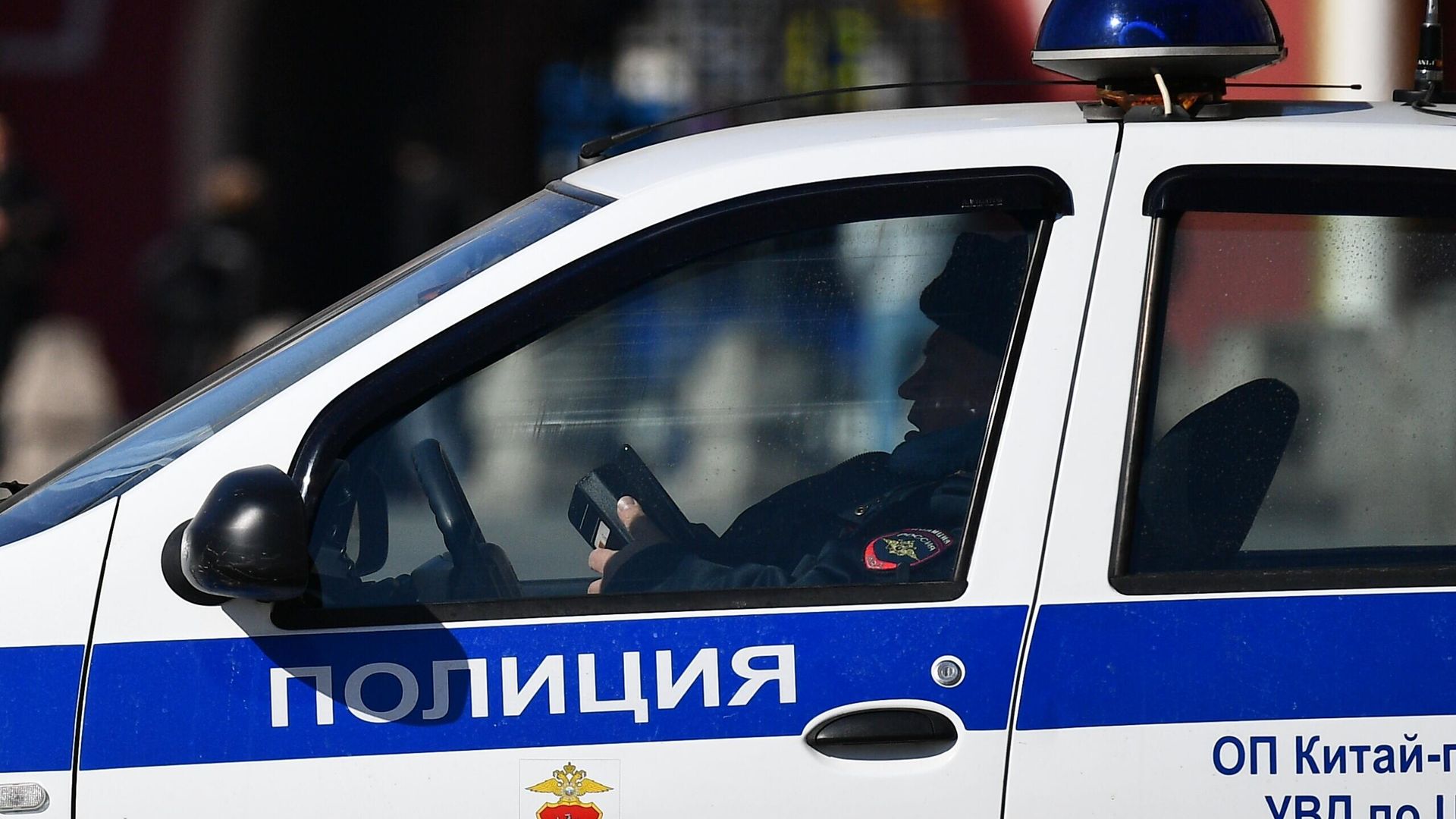 Сотрудник правоохранительных органов в полицейской машине в центре Москвы Сотрудник правоохранительных органов в полицейской машине в центре Москвы - РИА Новости, 1920, 30.07.2021