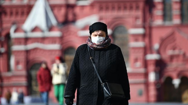 Женщина в защитной маске на Красной площади в Москве Женщина в защитной маске на Красной площади в Москве