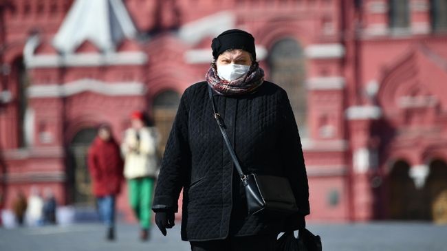 Женщина в защитной маске на Красной площади в Москве Женщина в защитной маске на Красной площади в Москве
