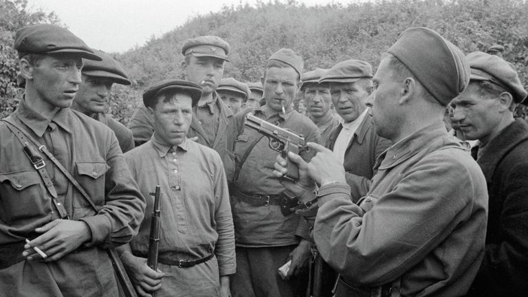 Командир партизанского отряда знакомит бойцов с оружием. Смоленская область, Россия