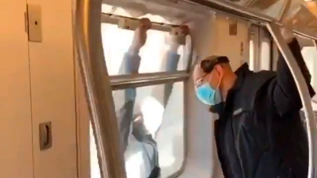 Мужчина висит на окне поезда Мужчина висит на окне поезда