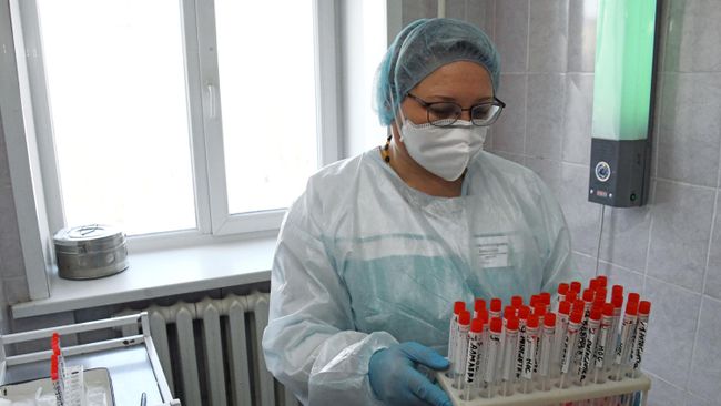 Врач держит в руках пробирки с образцами биоматериалов для тестирования на коронавирус Врач держит в руках пробирки с образцами биоматериалов для тестирования на коронавирус