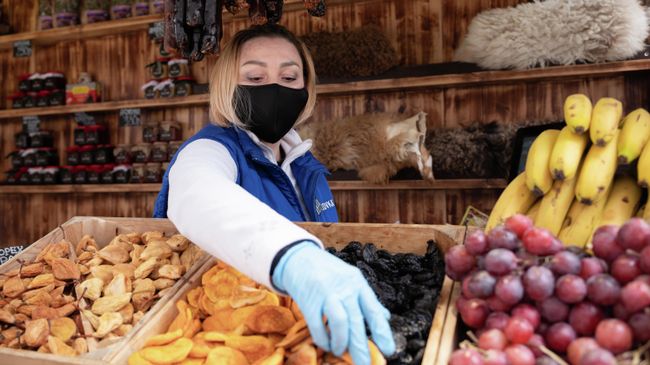 Продавец в защитной маске изображен на курорте Красная Поляна в Сочи, Россия Продавец в защитной маске изображен на курорте Красная Поляна в Сочи, Россия