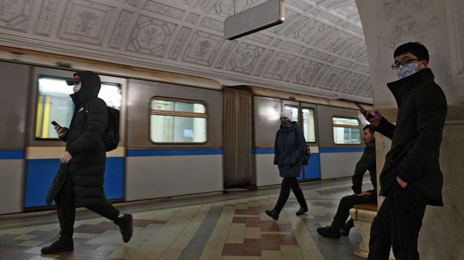 Пассажиры в медицинских масках на одной из станций метро в Москве Пассажиры в медицинских масках на одной из станций метро в Москве