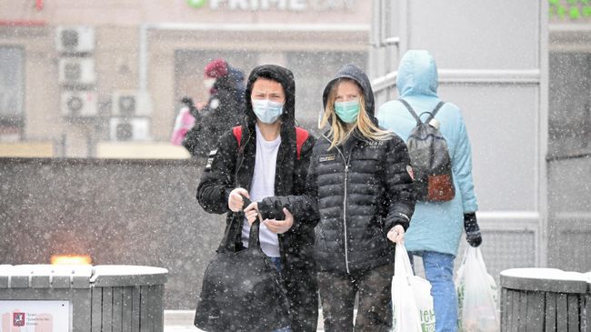 Молодые люди в медицинских масках на одной из улиц в Москве