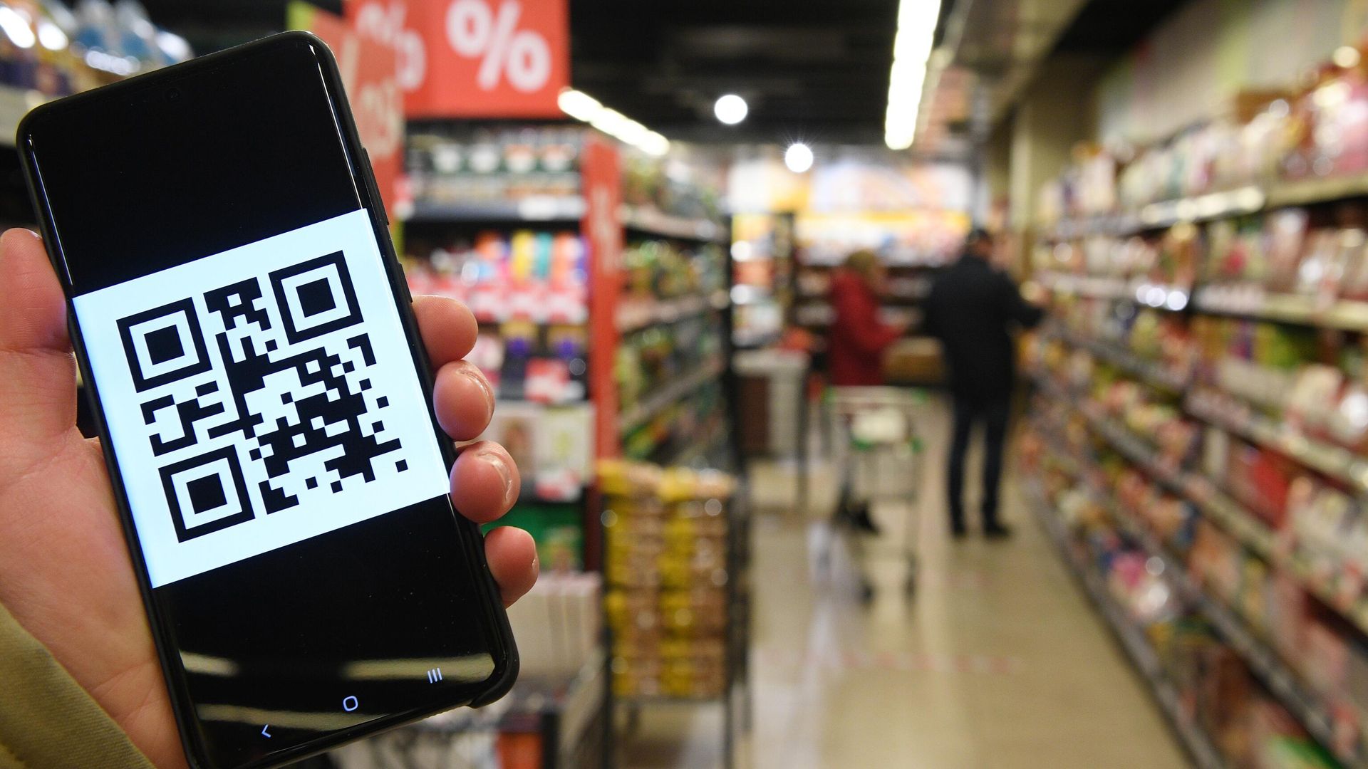Человек держит смартфон с изображением QR-кода Человек держит смартфон с изображением QR-кода - РИА Новости, 1920, 13.10.2020