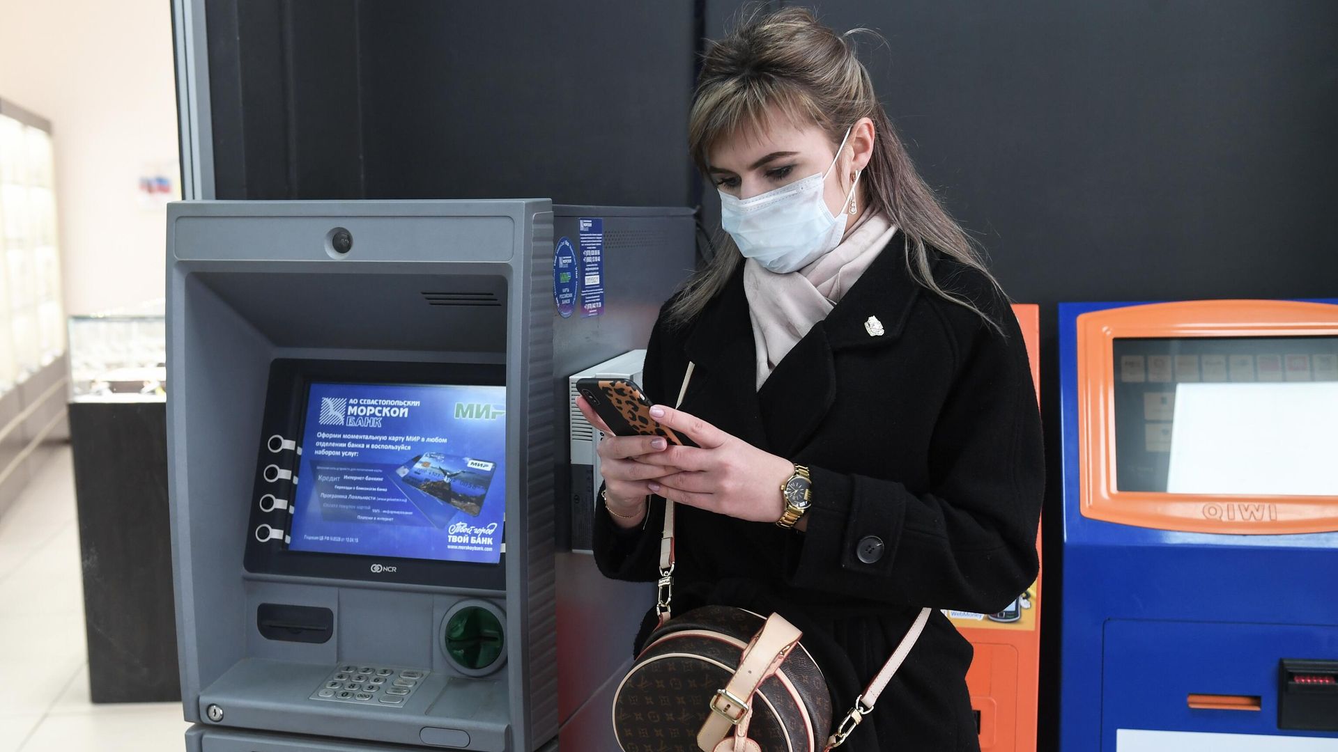Девушка стоит возле банкомата Девушка стоит возле банкомата - РИА Новости, 1920, 25.02.2022