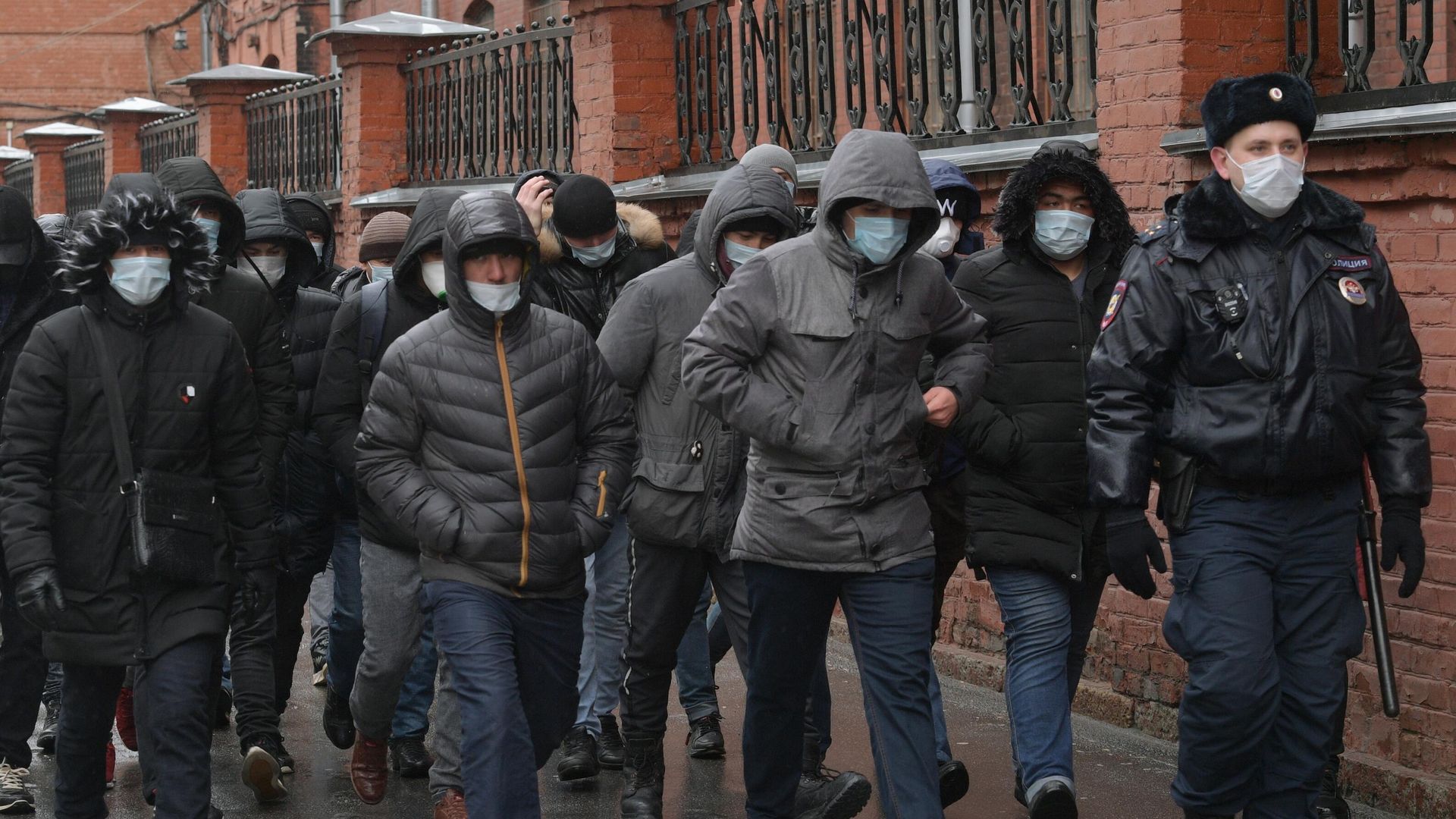 Сотрудник полиции выстраивает в очередь мигрантов у здания УФМС в Санкт-Петербурге - РИА Новости, 1920, 20.05.2021
