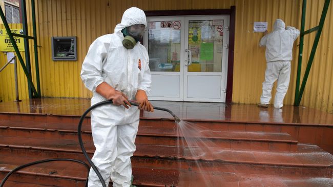 Сотрудник коммунальной службы проводит дезинфекцию у торговых рядов в городе Кировск в Ленинградской области Сотрудник коммунальной службы проводит дезинфекцию у торговых рядов в городе Кировск в Ленинградской области