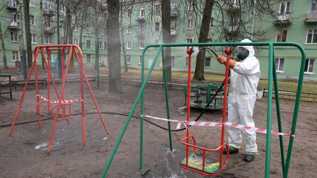 Сотрудник коммунальной службы проводит дезинфекцию на детской площадк Сотрудник коммунальной службы проводит дезинфекцию на детской площадк