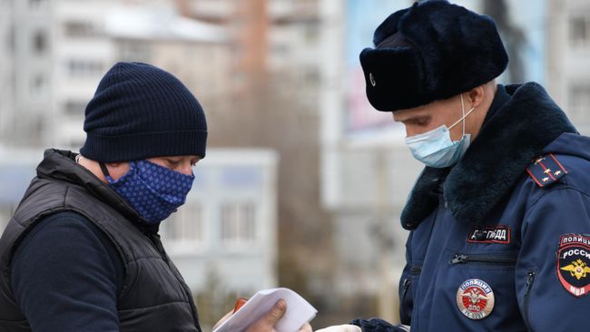 Сотрудник ГИБДД проверяет спецпропуск Сотрудник ГИБДД проверяет спецпропуск