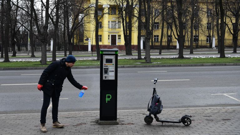 Мужчина дезинфицирует паркомат на улице в Москве Мужчина дезинфицирует паркомат на улице в Москве