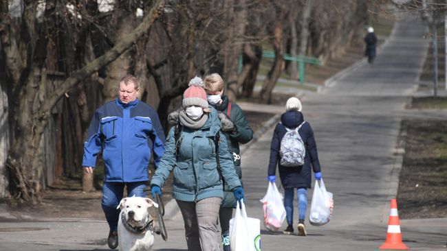 Люди в защитных масках на улице Люди в защитных масках на улице