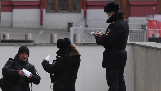 Сотрудники полиции проверяет документы у мужчины в Москве Сотрудники полиции проверяет документы у мужчины в Москве