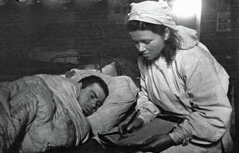 Сестра медсанбата пишет письмо родным под диктовку раненого солдата. 1-ый Прибалтийский фронт Сестра медсанбата пишет письмо родным под диктовку раненого солдата. 1-ый Прибалтийский фронт