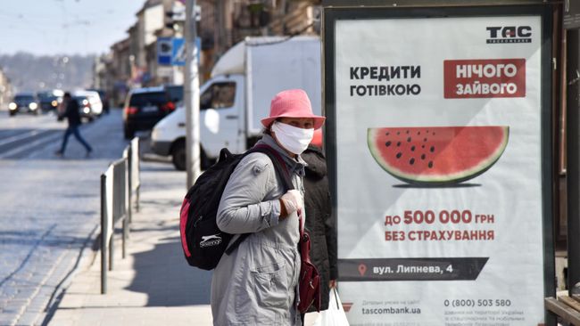 Женщина в защитной маске на одной из улиц во Львове