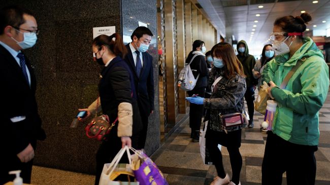 Сотрудники торгового центра проверяют QR-коды на вход в магазин у покупателей Сотрудники торгового центра проверяют QR-коды на вход в магазин у покупателей