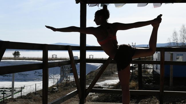 Сноубордистка во время ежедневной тренировки по общей физической подготовке и йоге Сноубордистка во время ежедневной тренировки по общей физической подготовке и йоге