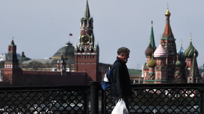 Прохожий с защитной маской на большом Устьинском мосту в Москве Прохожий с защитной маской на большом Устьинском мосту в Москве